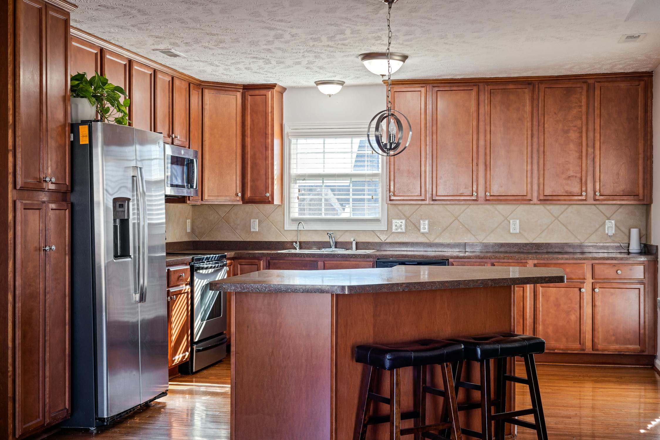 Stained alder kitchen cabinets with warm brown finish and island in eastern Idaho